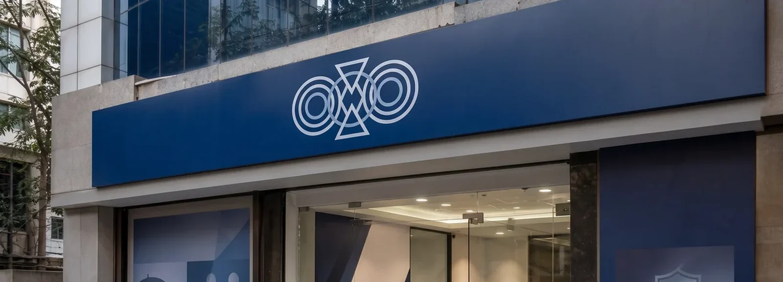 Office frontage with a navy fascia, window graphics showing family and protection imagery, and a shield-and-hand panel