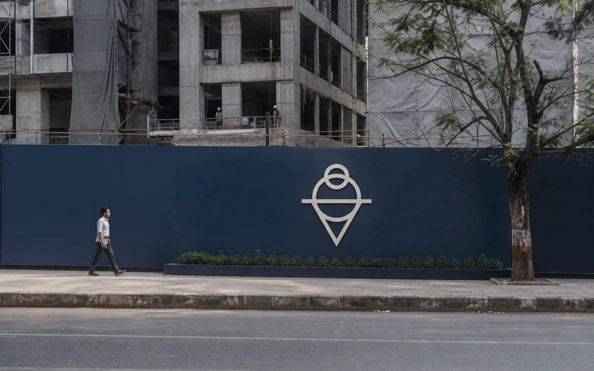 Construction site barricade covered in navy printed panels along a street